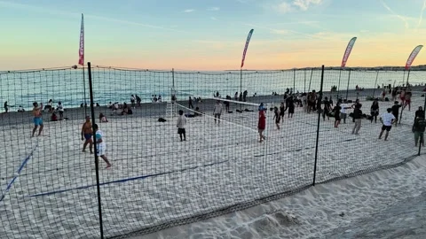 Young people preparing to play beach volleyball at sunset Video stock 336923070