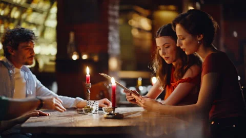 Young people reading menu at couples date in contemporary restaurant closeup. Stock Footage 334033415