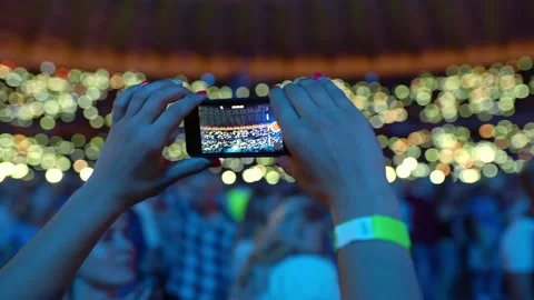 Young people record video on the phone in the crowd at the concert, close up 動画素材 223948643