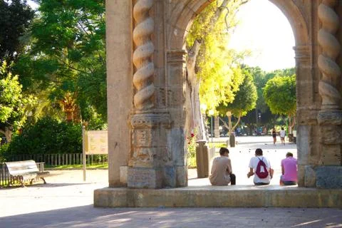 Young people rest in the shade while talking in the park Stock Photos