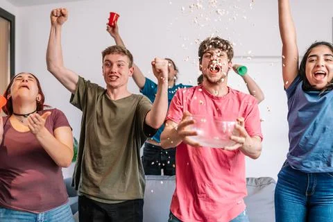 Young people screaming with excitement throwing popcorn in the air after their Stock Photos