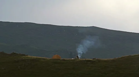 Young people starts a fire at mountain camp. Видео 44519076