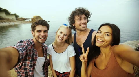 Young people taking selfies on the beach Stock Footage 68800626