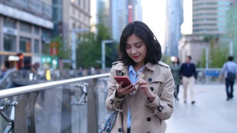 Young people using mobile phone walking in the street,4k Stock Footage