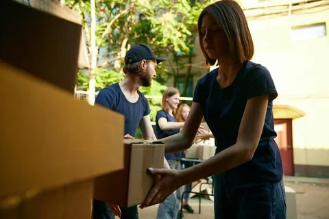 Young people, volunteers loading boxes into van. Gathering food, clothes and 스톡 사진