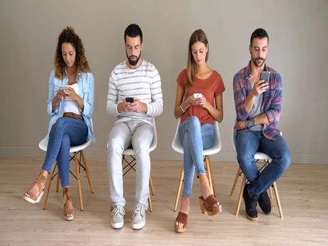Young people in waiting room using smartphones Stock Footage 80138443