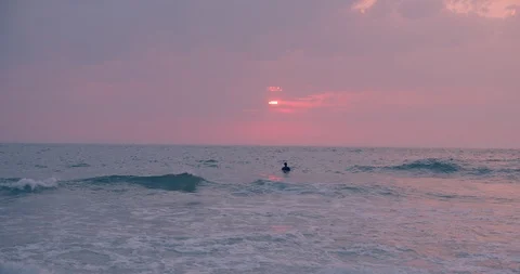 Young people in wetsuit surf on sunset beach Stock Footage 123732858