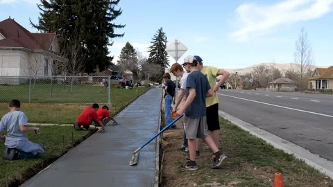 Young people work on new sidewalk as community service project Stock Footage 88712595