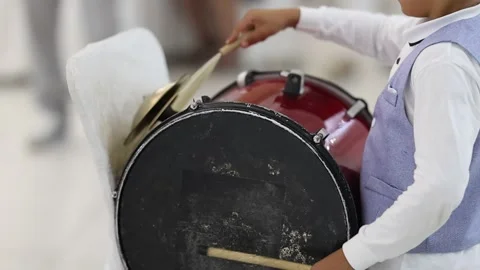 Young percussionists striking worn drumhead and brass cymbals during lively 스톡 동영상 346083374