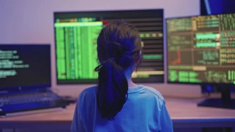 Young person analyzing data on multiple screens in a dimly lit room, focuse.. Stock Footage 319928944