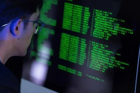 Young person coding on computer with green text screen in a dark room durin.. Stock Photos