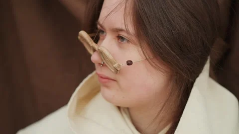 Young person with Down syndrome balancing burlap nose prop in soft warm portrait Stock Footage 343686684