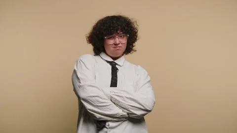 Young person makes funny faces while posing against a plain background in a.. Vidéo 331990569