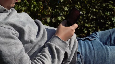 Young person sitting and using smartphone indoors, social media addiction Stock Footage 318371218
