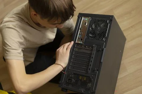 A young person skillfully assembles computer components, showing tech interes Foto stock