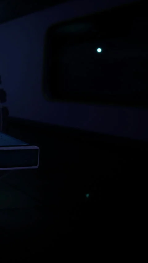 Young person studying alone at a desk in dimly lit room during night Stock Footage 334264989