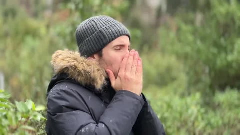 Young person trying to keep warm during a snowfall Stock Footage 326236463