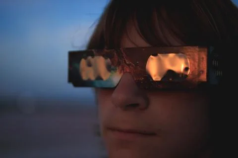 Young person using protective solar eclipse glasses, looking up at the sky .. Stock Photos