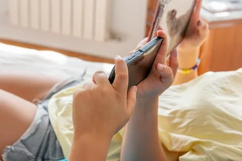 Young person using smartphone engaging screen time Stock Photos