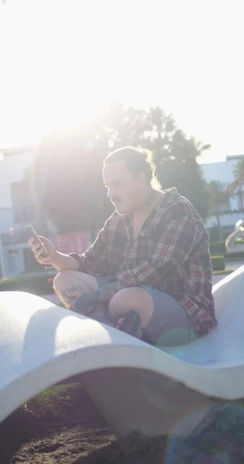 Young Person Using Smartphone While Sitting On Modern Outdoor... 库存影片 333525122