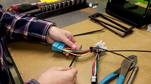 Young person using zip tie to tie harness | car stereo harness 스톡 동영상 168787403