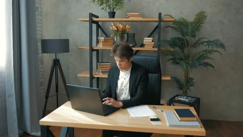 Young perspective businessman is actively working while sitting at the table in Stock Footage 155348665