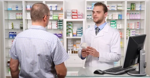 Young Pharmacist Man Explaining to a Patient Medicine Advise in Pharmacy Concept Video stock 73554250