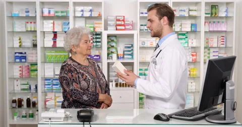 Young Pharmacist Man Talking Medicine Give Old Woman Patient Healthcare Counsel Stock Footage