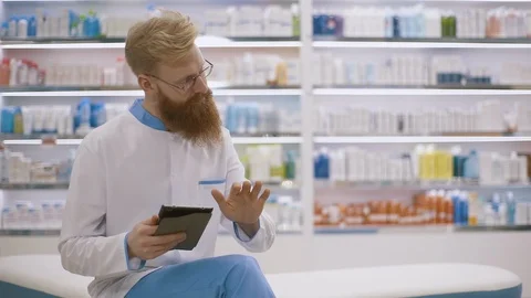 Young pharmacist using tablet pc at the hospital pharmacy. Slow motion. Stock Footage 127279407