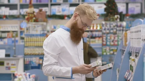 Young pharmacist working in his large pharmacy. Placing medications inventory Stock Footage 127317568
