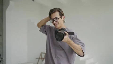 Young photographer with glasses in process of working on photo shoot Stock Footage 242777347