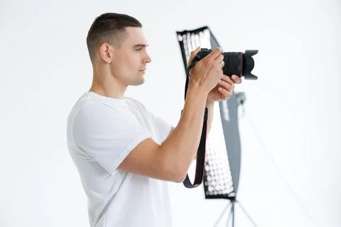 Young photographer in the process of shooting in the Studio Stock Photos