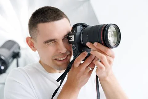 Young photographer in the process of shooting in the Studio Stock Photos