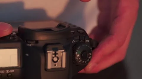 A young photographer sets up his camera, holding it in his hands, in the light Stock Footage 246122813