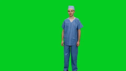 Young physician in uniform presenting something with copy space on green screen Видео 126339939