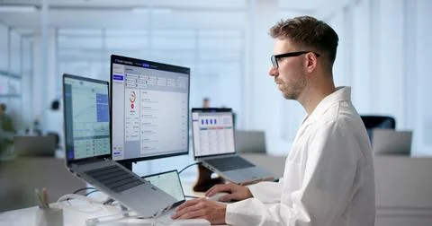 Young Physician Uses Laptop Software To Review Licensing And Credentialing Da Stock Photos