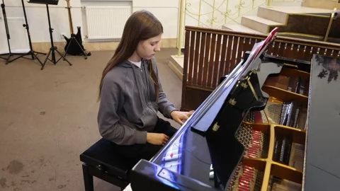 Young pianist performs in an elegant hall with stained glass windows Stock Footage 297398891
