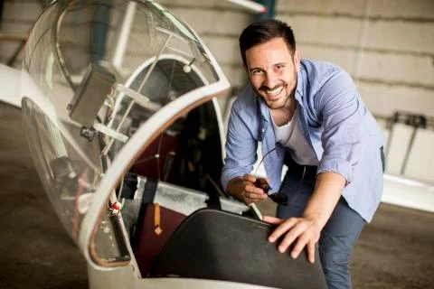 Young pilot checking airplane in the hangar Stock Photos