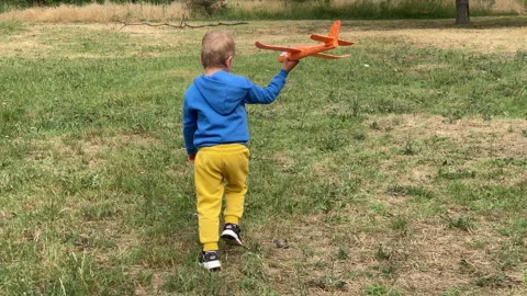 Young Pilot Joyful Flight: A Child Outdoor Adventure with a Toy Plane Stock Footage 315349387