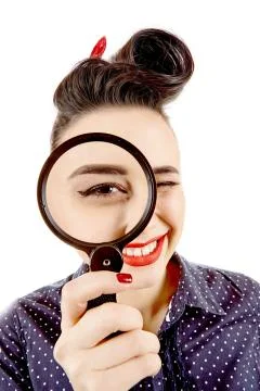 Young pinup girl with magnifying glass Stock Photos
