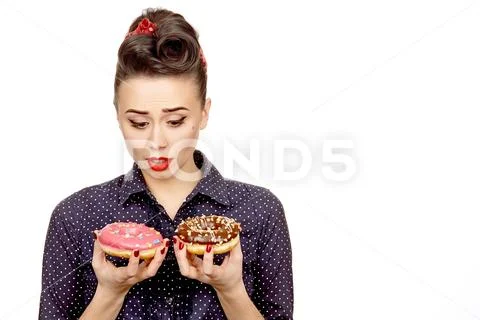 Young pinup woman choosing a donut to eat Stock Photos