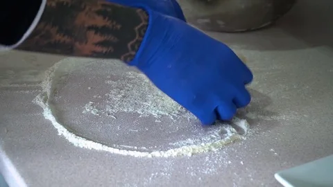 A young pizza maker prepares pizza in the kitchen of the restaurant. Mix the Video stock 84829287