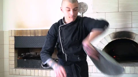 A young pizza maker prepares pizza in the kitchen of the restaurant. The cook Stock Footage 84829496