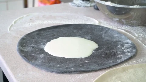 A young pizza maker prepares pizza in the kitchen of the restaurant. Prepares Stock Footage 84829569