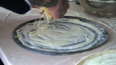 A young pizza maker prepares pizza in the kitchen of the restaurant. Prepares Stock Footage 84829643