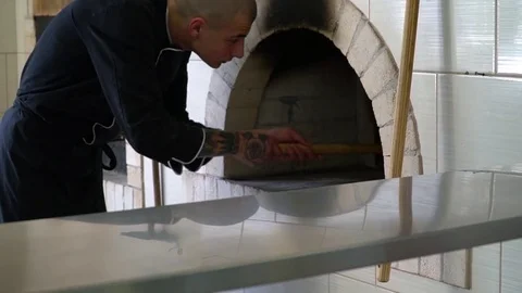 A young pizza maker prepares pizza in the kitchen of the restaurant. The cook Stock Footage 84830584