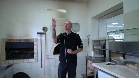 A young pizza maker prepares pizza in the kitchen of the restaurant. The cook Stock Footage 84830608