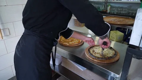 A young pizza maker prepares pizza in the kitchen of the restaurant. The cook Stock Footage 84830698