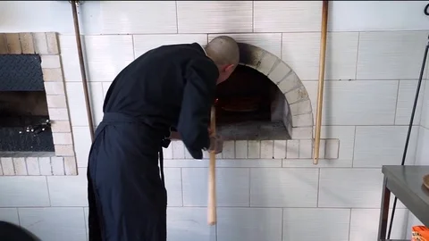 A young pizza maker prepares pizza in the kitchen of the restaurant. The cook Stock Footage 84831179