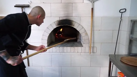 A young pizza maker prepares pizza in the kitchen of the restaurant. The cook Stock Footage 84831228